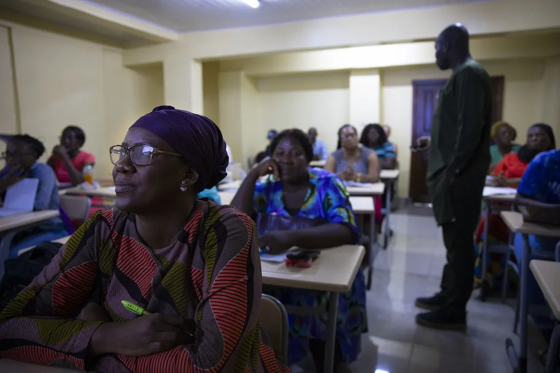 Dark room full of woman watching video on maternal health