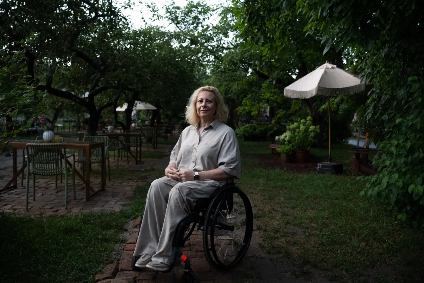 woman sitting in a wheelchair outside at a cafe